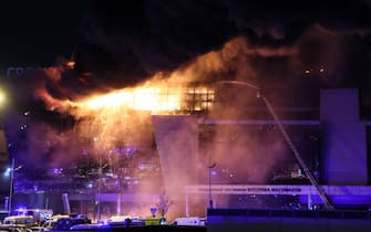 A view shows the burning Crocus City Hall concert hall following the shooting incident in Krasnogorsk, outside Moscow, on March 22, 2024. Gunmen opened fire at a concert hall in a Moscow suburb on March 22, 2024 leaving dead and wounded before a major fire spread through the building, Moscow's mayor and Russian news agencies reported. (Photo by STRINGER / AFP)