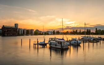 Berlin skyline, Rummelsburger See (lake Rummelsburg) with marina, in the district Lichtenberg,. View to the city skyline with famous television-tower and office buildings on the other side of the lake. Seen from a public park with residential buildings.