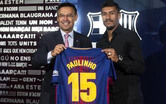 epa06148293 FC Barcelona's President Josep Maria Bartomeu (L) poses next to club's new Brazilian midfielder Jose Paulo Bezerra 'Paulinho' during his presentation at the Camp Nou stadium, in Barcelona, Spain, 17 August 2017. Paulinho, from Chinese Guangzhou Evergrande, signed a four-year contract with the team after the club paid 40 million euro.  EPA/QUIQUE GARCIA
