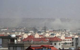 epa09430531 Smoke billows from the airport area after a blast outside the Hamid Karzai International Airport, in Kabul, Afghanistan, 26 August 2021. At least 13 people including children were killed in a blast outside the airport on 26 August. The blast occurred outside the Abbey Gate and follows recent security warnings of attacks ahead of the 31 August deadline for US troops withdrawal.  EPA/AKHTER GULFAM