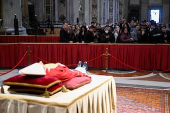 A handout picture provided by the Vatican Media shows faithful pay their respects to Pope Emeritus Benedict XVI (Joseph Ratzinger) whose body lies in state in the Saint Peter's Basilica for public viewing, Vatican City, 02 January 2023. The funeral will take place on Thursday 05 January. 
ANSA/ VATICAN MEDIA +++ ANSA PROVIDES ACCESS TO THIS HANDOUT PHOTO TO BE USED SOLELY TO ILLUSTRATE NEWS REPORTING OR COMMENTARY ON THE FACTS OR EVENTS DEPICTED IN THIS IMAGE; NO ARCHIVING; NO LICENSING +++ (NPK)
