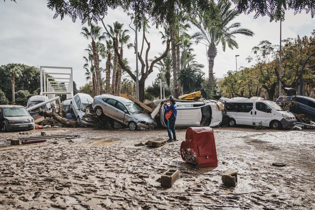VALENCIA, SPAIN - OCTOBER 31: A woman is next to the wrecked cars after catastrophic flash floods due to heavy rain in Sedavi district of Valencia, Spain on October 31, 2024. Historic storm killed at least 158 people and caused widespread destruction in the province of Valencia, with many people still missing. (Photo by Borja Abargues/Anadolu via Getty Images)