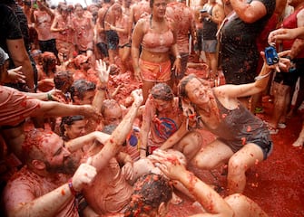 epa10828576 People participate in La Tomatina, a traditional and world-wide known tomato fight festival, in Bunol, Valencia province, eastern Spain, 30 August 2023. As every year on the last Wednesday of August, thousands of people visit the small village of Bunol to attend the Tomatina, a battle in which tons of ripe tomatoes are used to throw at each other.  EPA/MIGUEL ANGEL POLO