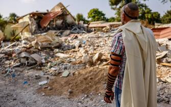 epaselect epa10932726 A man prays in front of destroyed houses in Kibbutz Be'eri, Israel, 22 October 2023. More than 4,500 Palestinians and 1,400 Israelis have been killed, according to the Israel Defense Forces (IDF) and the Palestinian health authority, since Hamas militants launched an attack against Israel from the Gaza Strip on 07 October.  EPA/HANNIBAL HANSCHKE