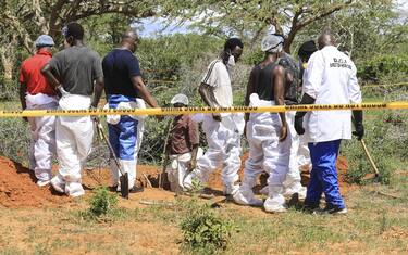 epa10588058 Kenyan homicide detectives and forensic experts from the Directorate of Criminal Investigations (DCI), examine exhumed bodies from several shallow mass graves of suspected members of a Christian cult after starving themselves to death, after allegedly being told by their controversial preacher Paul Mackenzie that they would go to heaven if they starved themselves to death, in the coastal Shakahola forest, in Kilifi, Kenya, 23 April 2023. According to the Police, 18 more bodies were exhumed on 23 April bringing the tally of bodies recovered to at 39.  EPA/STR