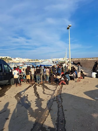 Migranti giunti a Lampedusa in attesa dei trasferimenti, 13 settembre 2023.
//////////
A group of migrants wait on the island of Lampedusa as Italian authorities prepare for transferring people following new arrivals, southern Italy, 13 September 2023. 
ANSA/CONCETTA RIZZO