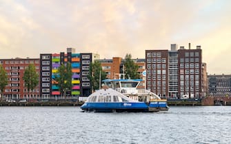 Ferry boat and apartment buildings on Java Island in Eastern Docklands of Amsterdam, Netherlands