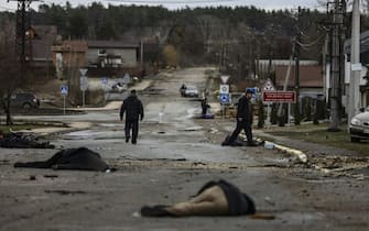 EDITORS NOTE: Graphic content / TOPSHOT - In this photo taken on April 02, 2022 bodies of civilian lie on Yablunska street in Bucha, northwest of Kyiv, after Russian army pull back from the city. The first body on the picture has been identified as Mykhailo Kovalenko and was shot dead by Russian soldiers according to relatives interviewed by AFP. When the 62-year-old arrived on Yablunska, he "got out of the vehicle with his hands up" to present himself to a checkpoint manned by Russian soldiers, said Artem, the boyfriend of Kovalenkos daughter. Still, the troops opened fire, said his daughter and his wife, who survived the attack by running away. - The bodies of at least 20 men in civilian clothes were found lying in a single street Saturday after Ukrainian forces retook the town of Bucha near Kyiv from Russian troops, AFP journalists said. Russian forces withdrew from several towns near Kyiv in recent days after Moscow's bid to encircle the capital failed, with Ukraine declaring that Bucha had been "liberated". (Photo by RONALDO SCHEMIDT / AFP) (Photo by RONALDO SCHEMIDT/AFP via Getty Images)