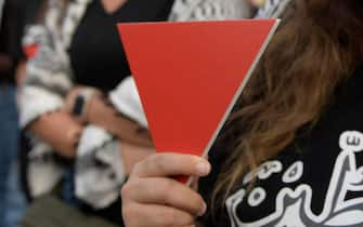 A protester holds an inverted "red triangle", a symbol that the Palestinian Hamas movement's military wing Al-Qassam Brigades uses to identify Israeli targets in their videos, during a solidarity sit-in with the Gaza Strip, in Manama on November 17, 2023, amid ongoing battles between Israel and Hamas militants. (Photo by Mazen Mahdi / AFP) (Photo by MAZEN MAHDI/AFP via Getty Images)