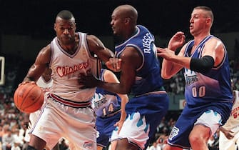 LOS ANGELES, UNITED STATES:  Los Angeles Clipers player Loy Vaught (L) attempts to drive between Utah Jazz players Bryon Russell (C) and Greg Ostertag (R) during the third game of an NBA Western Conference playoff game 28 April in Los Angeles. The Jazz defeated the Clippers 104-92 to sweep the best-of-five series 3-0 and advance to round two of the playoffs.     AFP PHOTO   Hector MATA/hmb (Photo credit should read HECTOR MATA/AFP via Getty Images)