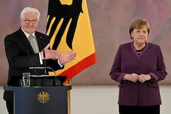 epa10577256 Former German Chancellor Angela Merkel (R) looks on as she is introduced by German President Frank-Walter Steinmeier (L) as laureate to receive the 'Grand Cross of the Order of Merit of the Federal Republic of Germany'  during a ceremony at the Bellevue Palace in Berlin, Germany, 17 April 2023.  EPA/FILIP SINGER