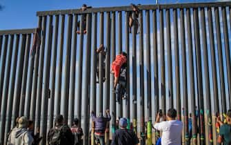 epaselect epa07449522 Migrants attempt to enter the United States illegally from the Playas Tijuana area in the Mexican state of Baja California, Mexico, 19 March 2019. According to witnesses, around a hundred people arrived at the seashore in the Mexican town to attempt to climb the metal fence that stands on the border between the two countries.  EPA/JOEBETH TERRIQUEZ