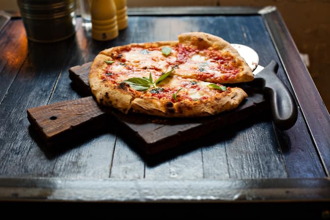 Pizza Margherita freshly baked on a table in cafe