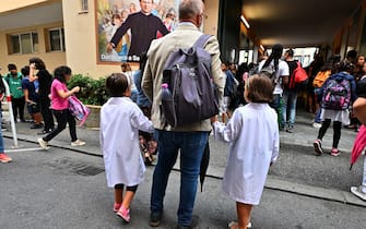Bambini e adulti davanti a una scuola elementare