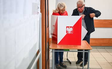 WARSAW, POLAND - OCTOBER 15: A couple casts their ballots at a polling station during Poland's parliamentary elections on October 15, 2023 in Warsaw, Poland. Poles are voting today to decide whether the ruling national conservative Law and Justice party (PiS), led by Jaroslaw Kaczynski, will govern for a third consecutive term, or whether a coalition of center-left, pro-European parties will be given the opportunity to form a government. Also on the ballot is a referendum introduced by the current government over EU migration reform. (Photo by Omar Marques/Getty Images)