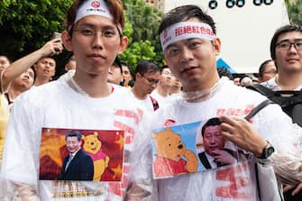 Protesters standing in the heavy rain wearing  t-shirts representing The President of the People's Republic of China President Xi Jinping  together with  Winnie the Pooh , in Taipei, Taiwanm on June 23, 2019. Thousands of Taiwanese took the street of Taipei (despite the heavy rain) to protest against the &quot;Chinese Media&quot; in implanted Taiwan and also to claim their opposition to the Chinese Communist Party's (CCP) authoritarian rule in China. (Photo by Jose Lopes Amaral/NurPhoto via Getty Images)