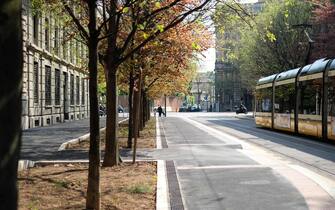 Milan, LOM, Italy - April 17 2021: Street with trees in the city, concept of surface mobility by subway or on foot.