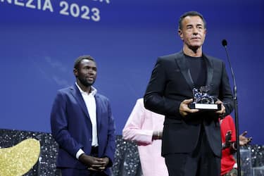 VENICE, ITALY - SEPTEMBER 09: Mamadou Kouassi and Matteo Garrone with the Silver Lion for Best Director for film â  Io Capitanoâ   on stage during the Awards ceremony at the 80th Venice International Film Festival on September 09, 2023 in Venice, Italy. (Photo by Vittorio Zunino Celotto/Getty Images)