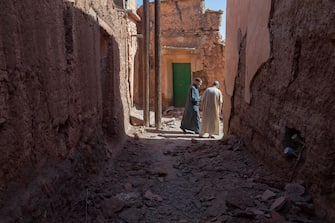 epa10850145 Two persons walk along a street with damaged buildings following an earthquake in Marrakesh, Morocco, 09 September 2023. A powerful earthquake that hit central Morocco late 08 September, killed at least 820 people and injured 672 others, according to a provisional report from the country's Interior Ministry. The earthquake, measuring magnitude 6.8 according to the USGS, damaged buildings from villages and towns in the Atlas Mountains to Marrakesh.  EPA/JALAL MORCHIDI