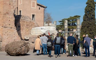 Rome, Italy - March 17th, 2022. Large group of tourists with a tourist guide explaining history on the Palatine Hill in Rome, Italy
