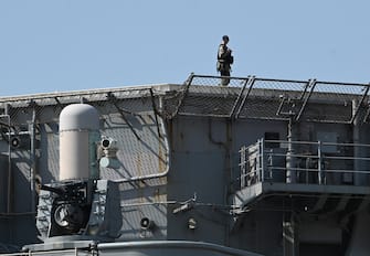 A sailor armed with an assault rifle patrols past a 20 mm Phalanx CIWS mount (L) on the amphibious assault ship USS America anchored at the international port in Manila on March 21, 2023. (Photo by Ted ALJIBE / AFP) (Photo by TED ALJIBE/AFP via Getty Images)