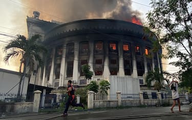 epa10645214 Smoke rises from the burning Philippine Central Post Office building in Manila, Philippines, 22 May 2023. A massive fire hit the Central Post Office where the main mail sorting and distribution operations of the country are. Arson investigators are still conducting an investigation of the possible cause of the fire and extent of damage to the postal headquarters.  EPA/FRANCIS R. MALASIG