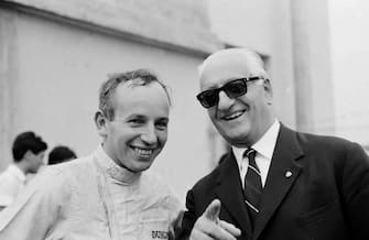FILE - This is a Sept. 4, 1964  file photo,  British ace driver John Surtees, left, and Italian racing car manufacturer Enzo Ferrari at the Ferrari pit of the Monza racing track, Italy.  Surtees, the only man to win world titles on both two and four wheels, has died aged 83, his family said Friday March 10, 2017.  Surtees won the Formula One title in 1964 to add to his 500cc motorcycle world titles from 1956, 1958, 1959 and 1960.  (ANSA/AP Photo/File) [CopyrightNotice: AP1964]