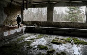 epa09138013 A man walks near the pool in abandoned city of Prypyat, near Chernobyl, Ukraine, 15 April 2021. Ukraine will mark the 35th anniversary of Chernobyl tragedy on 26 April 2021. The explosion of reactor 4 of the Chernobyl nuclear power plant in the early hours of 26 April 1986 is still regarded as the worst nuclear disaster ever.  EPA/OLEG PETRASYUK