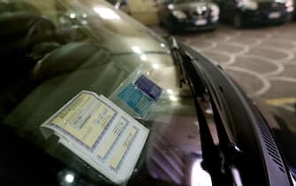 Il contrassegno di carta, ricevuta dell'assicurazione auto, sul parabrezza di una vettura.
ANSA/ALESSANDRO DI MEO