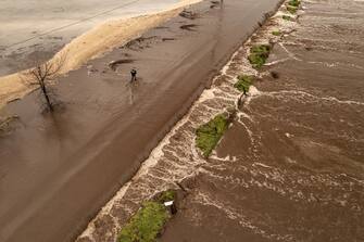 PORTERVILLE, CA - MARCH 10: In an aerial view, a man walks on a road flooded over by Deer Creek on March 10, 2023 near Porterville, California. Another in a series of atmospheric river storms from the Pacific Ocean has brought a warm rain to the region, which is falling on top of, and melting, large areas of snow in the Sierra Nevada Mountains, increasing the risk of floods at lower elevations. This years destructive and deadly storms have produced heavy rains and a near-record snowpack in the Sierras, which provides water for millions of Californians. As a result of one of Californias wettest winters on record, most of the state has gotten relief from years of drought. (Photo by David McNew/Getty Images)