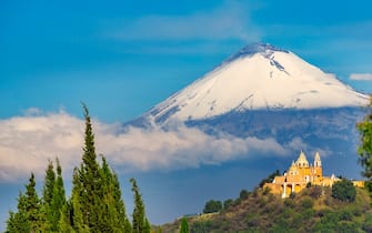Sanctuary of Nuestra Señora de los Remedios, built in the sixteenth century by the Spanish. Built atop the Tlachihualtepetl pyramid or The Great Pyramid of Cholula. In the background Popocatepetl volcano. Cholula. Puebla state. Mexico