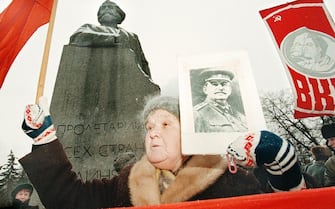 E07-21-12-1996-MOSCA, CRO. Un'anziana signora mostra un'immagine di Stalin e una bandiera rossa sotto il monumento a Karl Marx oggi a Mosca in occasione della celebrazione del 117mo anniversario della nascita di Stalin.  KGG                          ILYA PITALEV/ANSA