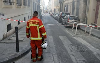 A naval fire officer looks at the 'rue Tivoli' after a building collapsed in the same street, in Marseille, southern France, on April 9, 2023. - "We have to be prepared to have victims," the mayor of Marseille warned on April 9, 2023 after a four-storey apartment building collapsed in the centre of France's second city, injuring five people, according to a provisional report. (Photo by NICOLAS TUCAT / AFP) (Photo by NICOLAS TUCAT/AFP via Getty Images)
