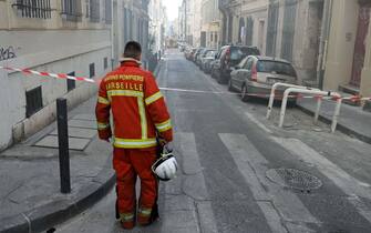 A naval fire officer looks at the 'rue Tivoli' after a building collapsed in the same street, in Marseille, southern France, on April 9, 2023. - "We have to be prepared to have victims," the mayor of Marseille warned on April 9, 2023 after a four-storey apartment building collapsed in the centre of France's second city, injuring five people, according to a provisional report. (Photo by NICOLAS TUCAT / AFP) (Photo by NICOLAS TUCAT/AFP via Getty Images)