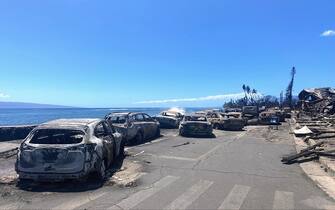 Burned cars and destroyed buildings are pictured in the aftermath of a wildfire in Lahaina, western Maui, Hawaii on August 11, 2023. A wildfire that left Lahaina in charred ruins has killed at least 55 people, authorities said on August 10, making it one of the deadliest disasters in the US state's history. Brushfires on Maui, fueled by high winds from Hurricane Dora passing to the south of Hawaii, broke out August 8 and rapidly engulfed Lahaina. (Photo by Paula RAMON / AFP) / "The erroneous mention[s] appearing in the metadata of this photo by Paula RAMON has been modified in AFP systems in the following manner: [August 11] instead of [August 10]. Please immediately remove the erroneous mention[s] from all your online services and delete it (them) from your servers. If you have been authorized by AFP to distribute it (them) to third parties, please ensure that the same actions are carried out by them. Failure to promptly comply with these instructions will entail liability on your part for any continued or post notification usage. Therefore we thank you very much for all your attention and prompt action. We are sorry for the inconvenience this notification may cause and remain at your disposal for any further information you may require." (Photo by PAULA RAMON/AFP via Getty Images)