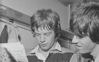 UNITED KINGDOM - 1st JANUARY: Mick Jagger and Keith Richards from The Rolling Stones read a newspaper backstage on tour in Scotland in early 1964. (Photo by Mark and Colleen Hayward/Redferns)