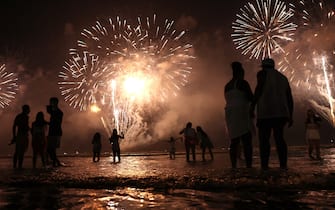 SANTOS, BRAZIL - JANUARY 01: Brazilians celebrate during fireworks marking the start of the New Year at Gonzaga beach on January 1, 2023 in Santos, Brazil. The funeral for Brazilian football icon Edson Arantes do Nascimento, better known as Pele, will be held in the city at Urbano Caldeira Stadium on January 2nd. (Photo by Mario Tama/Getty Images)