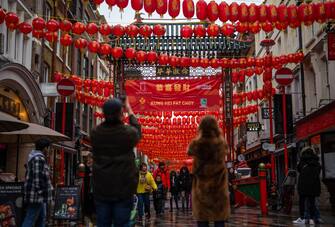 LONDON, ENGLAND - FEBRUARY 9: People view red lanterns hanging to mark the lunar new year in Chinatown on February 9, 2024 in London, England. Chinese New Year, also known as Lunar New Year, falls on Saturday, February 10, with Londoners welcoming the Year of the Dragon as festivities carry on through The Chinese New Year Parade on February 11th. (Photo by Carl Court/Getty Images)