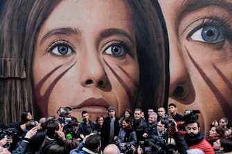 NAPLES, CAMPANIA, ITALY - 2018/11/20: Ilaria Cucchi (C) poses near the wall painting with her portrait made by the artist Jorit Agoch (R). Ilaria Cucchi is the sister of Stefano, dead in 2009 in prison after his arrest. Ilaria and his family have been fighting for nine years to bring to light the truth about the death of his brother and recently a member of Italian Carabinieri (military police) that was present during interrogations of Stefano Cucchi testify as he was victim of police brutality. (Photo by Mario Laporta/KONTROLAB /LightRocket via Getty Images)