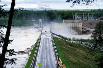 TOPSHOT - Water flows over a dam at the Braskereidfoss Power plant, Norway after floodgates did not open properly, on August 9, 2023. Norwegian authorities said on August 9 thousands had been evacuated following massive floods and that they were considering blowing open a dam after the floodgates failed to open. Norway's armed forces said they had been asked to assist police at the Braskereidfoss hydroelectric power station, which lies along the Glomma river -- the longest in Norway -- to evaluate whether the gates would need to be blasted open. (Photo by Cornelius Poppe / NTB / AFP) / Norway OUT (Photo by CORNELIUS POPPE/NTB/AFP via Getty Images)