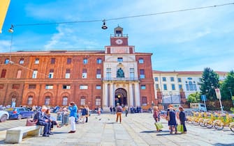 MILAN, ITALY - APRIL 11, 2022: The crowded Piazza Sant'Ambrogio with building of Universita Cattolica del Sacro Cuore, on April 11 in Milan, Italy