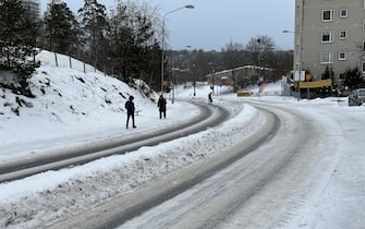 STOCKHOLM, SWEDEN - JANUARY 03: People walk on the snow covered sidewalk during the frosty weather in Stockholm, Sweden on January 03, 2024. Today was recorded as 'the coldest day in January in Sweden in the last 25 years' while temperatures in the Scandinavian region fell below minus 40 degrees centigrade for two consecutive days. (Photo by Atila Altuntas/Anadolu via Getty Images)