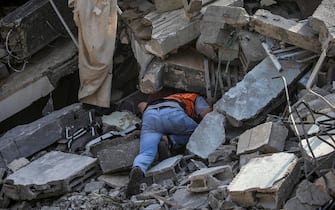 epa10937793 A Palestinian man searches for bodies and survivors among the rubble of the destroyed Al Shawa family house following an airstrike in Gaza, 25 October 2023. At least 13 members of the family were confirmed dead while eight others were still missing under the rubble following an early morning airstrike, according to Palestinian Civil Defence. More than 5,500 Palestinians and over 1,400 Israelis have been killed, according to the Israel Defense Forces (IDF) and the Palestinian health authority, since Hamas militants launched an attack against Israel from the Gaza Strip on 07 October, and the Israeli operations in Gaza and the West Bank which followed it.  EPA/MOHAMMED SABER