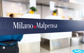 Malpensa, Italy, June 21 2023: Blue retractable belt barrier with white Milano Malpensa airport logo. Italian international airport located in the reg