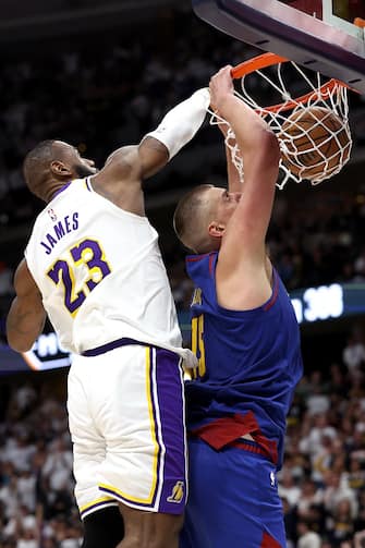 DENVER, COLORADO - APRIL 20: Nikola Jokic #15 of the Denver Nuggets dunks on LeBron James #23 of the Los Angeles Lakers in the fourth quarter during game one of the Western Conference First Round Playoffs at Ball Arena on April 20, 2024 in Denver, Colorado.  NOTE TO USER: User expressly acknowledges and agrees that, by downloading and or using this photograph, User is consenting to the terms and conditions of the Getty Images License Agreement. (Photo by Matthew Stockman/Getty Images)