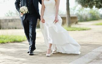 Bride and groom walking together in a park in wedding day