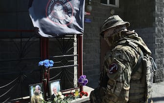 A member of private mercenary group Wagner pays tribute to Yevgeny Prigozhin at the makeshift memorial in front of the PMC Wagner office in Novosibirsk, on August 24, 2023. Russian state-run news agencies on August 23, 2023 said that Yevgeny Prigozhin, the head of the Wagner group that led a mutiny against Russia's army in June, was on the list of passengers of a plane that crashed near the village of Kuzhenkino in the Tver region. (Photo by Vladimir NIKOLAYEV / AFP) (Photo by VLADIMIR NIKOLAYEV/AFP via Getty Images)