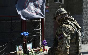 A member of private mercenary group Wagner pays tribute to Yevgeny Prigozhin at the makeshift memorial in front of the PMC Wagner office in Novosibirsk, on August 24, 2023. Russian state-run news agencies on August 23, 2023 said that Yevgeny Prigozhin, the head of the Wagner group that led a mutiny against Russia's army in June, was on the list of passengers of a plane that crashed near the village of Kuzhenkino in the Tver region. (Photo by Vladimir NIKOLAYEV / AFP) (Photo by VLADIMIR NIKOLAYEV/AFP via Getty Images)