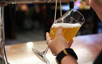 MANCHESTER, ENGLAND - JULY 19: A member of staff pours a pint for a customer at Wetherspoons pub The Moon Under Water on July 19, 2021 in Manchester, England. As of 12:01 on Monday, July 19, England will drop most of its remaining Covid-19 social restrictions, such as those requiring indoor mask-wearing and limits on group gatherings, among other rules. These changes come despite rising infections, pitting the country's vaccination programme against the virus's more contagious Delta variant. (Photo by Charlotte Tattersall/Getty Images)