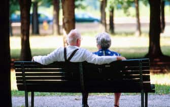 coppia di pensionati seduti su panchina
